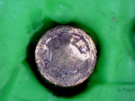 The bottom of a top pin that has sustained damage do to a variation in the design of the bottom pins.